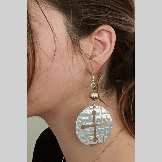 Earring with a cross design on a neutral background