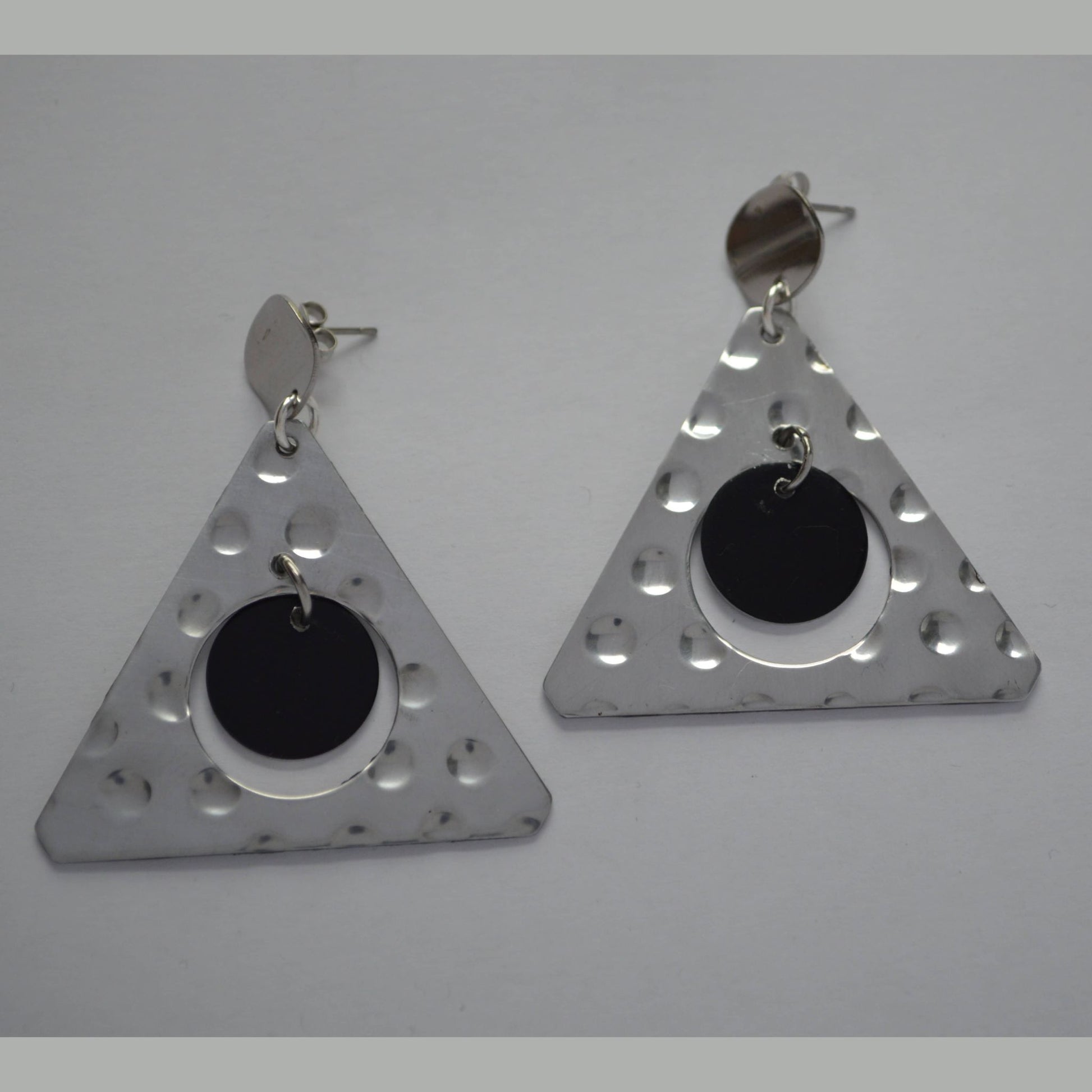 A pair of triangular hammered aluminum earrings with black anodized accents, displayed against a white background.