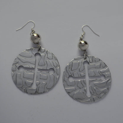 Pair of aluminum earrings  embossed textured with cross cutout on a gray background